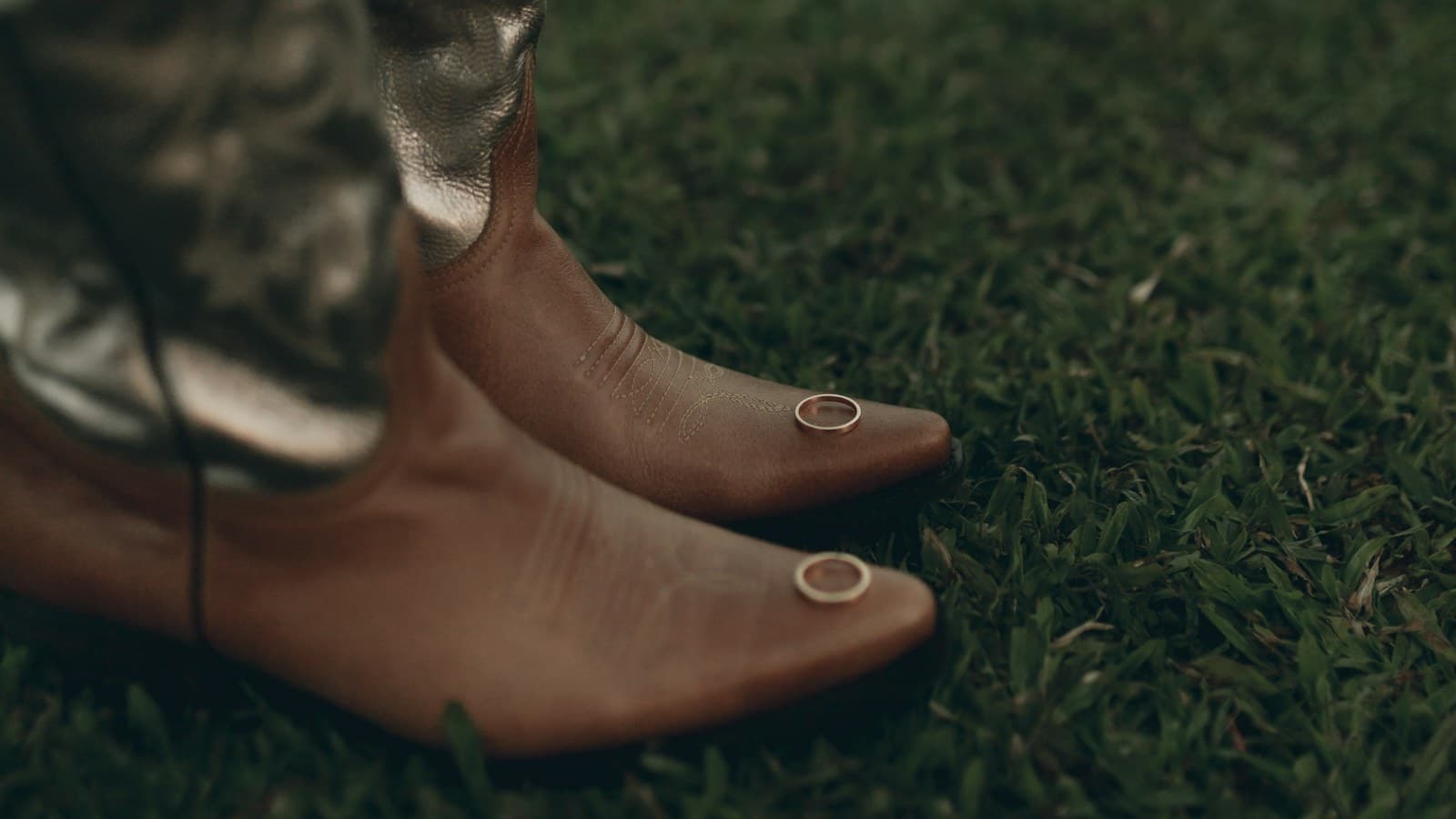 Cowboy boots with rings on toes on grass