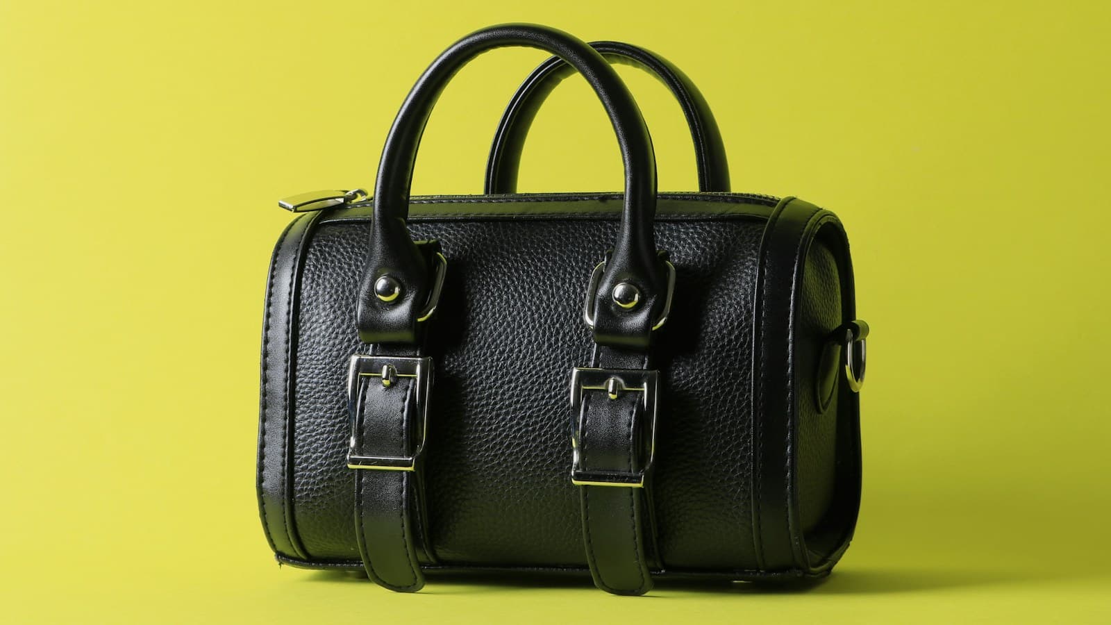a black leather bag on a yellow background