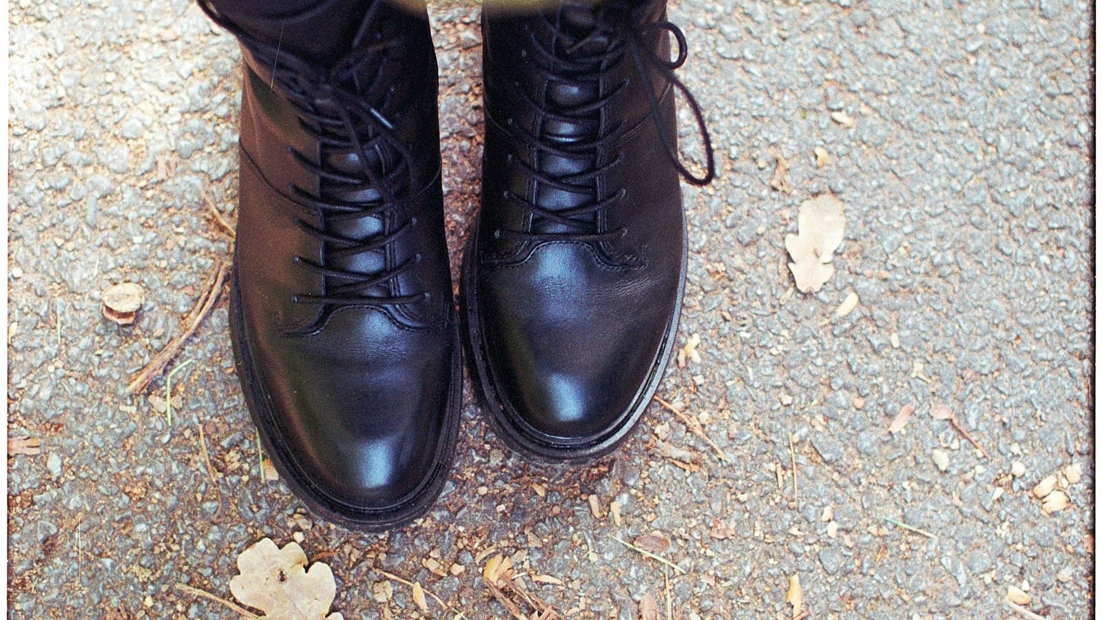 Black lace-up boots on a gravel path