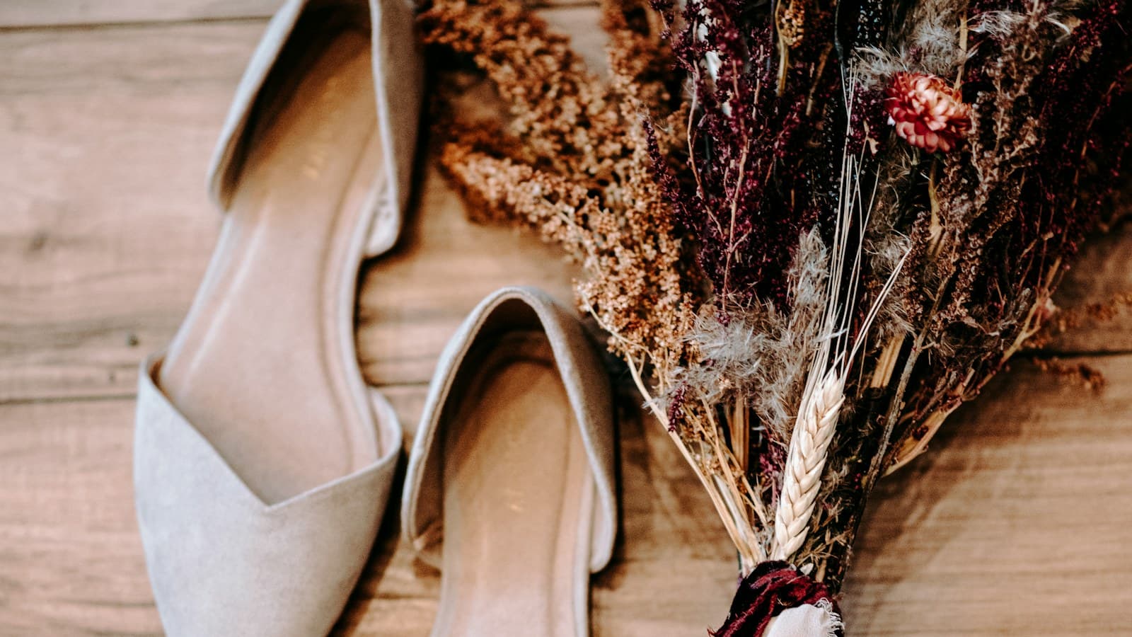 pair of shoes beside flowers