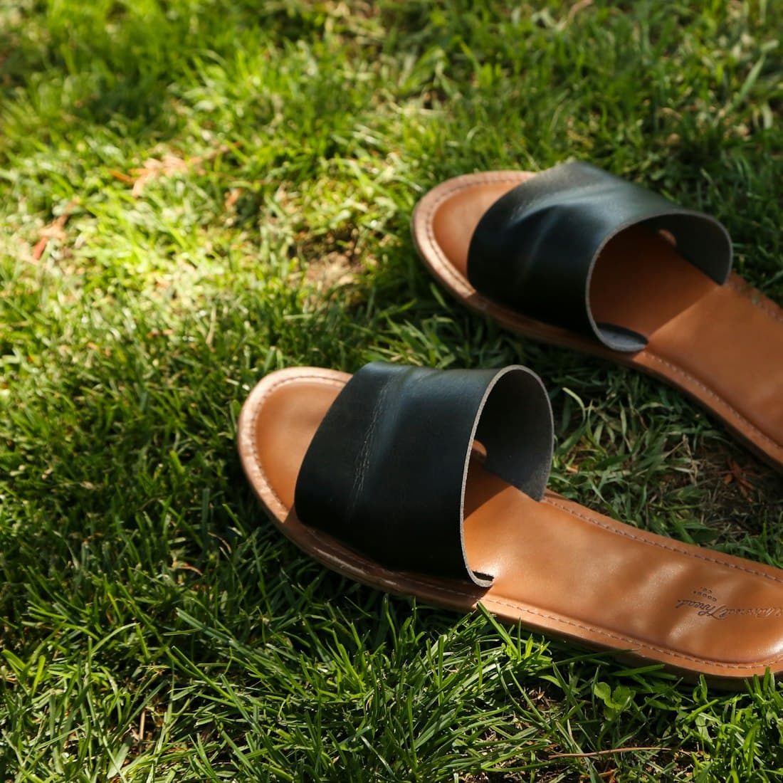 a pair of brown shoes on grass