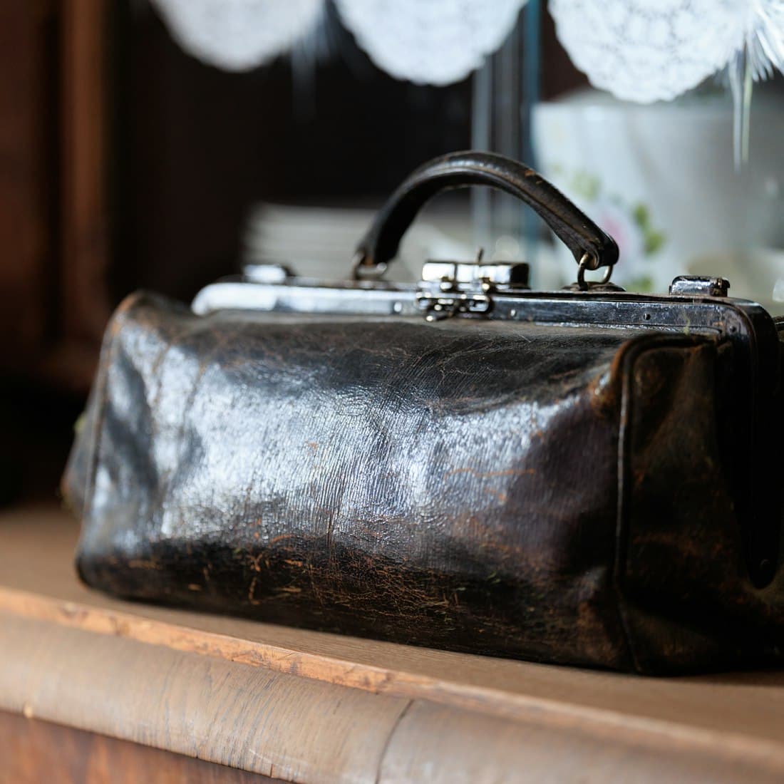 A vintage leather doctor's bag on a shelf