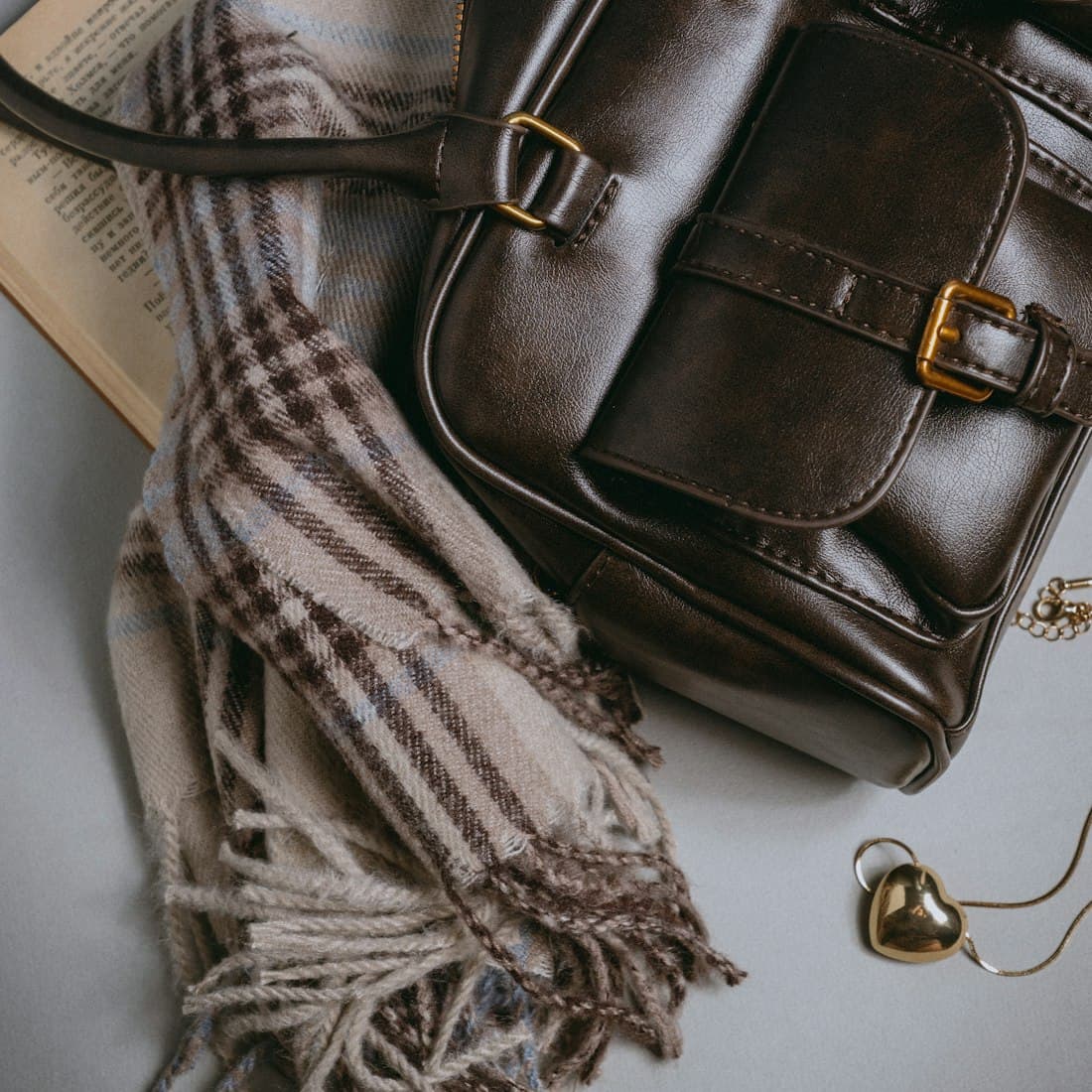A brown purse sitting on top of an open book
