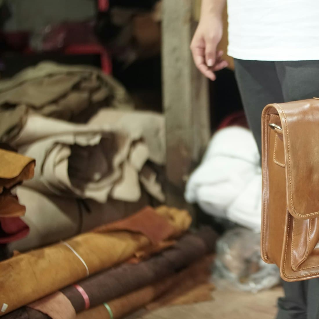 person carrying brown leather handbag