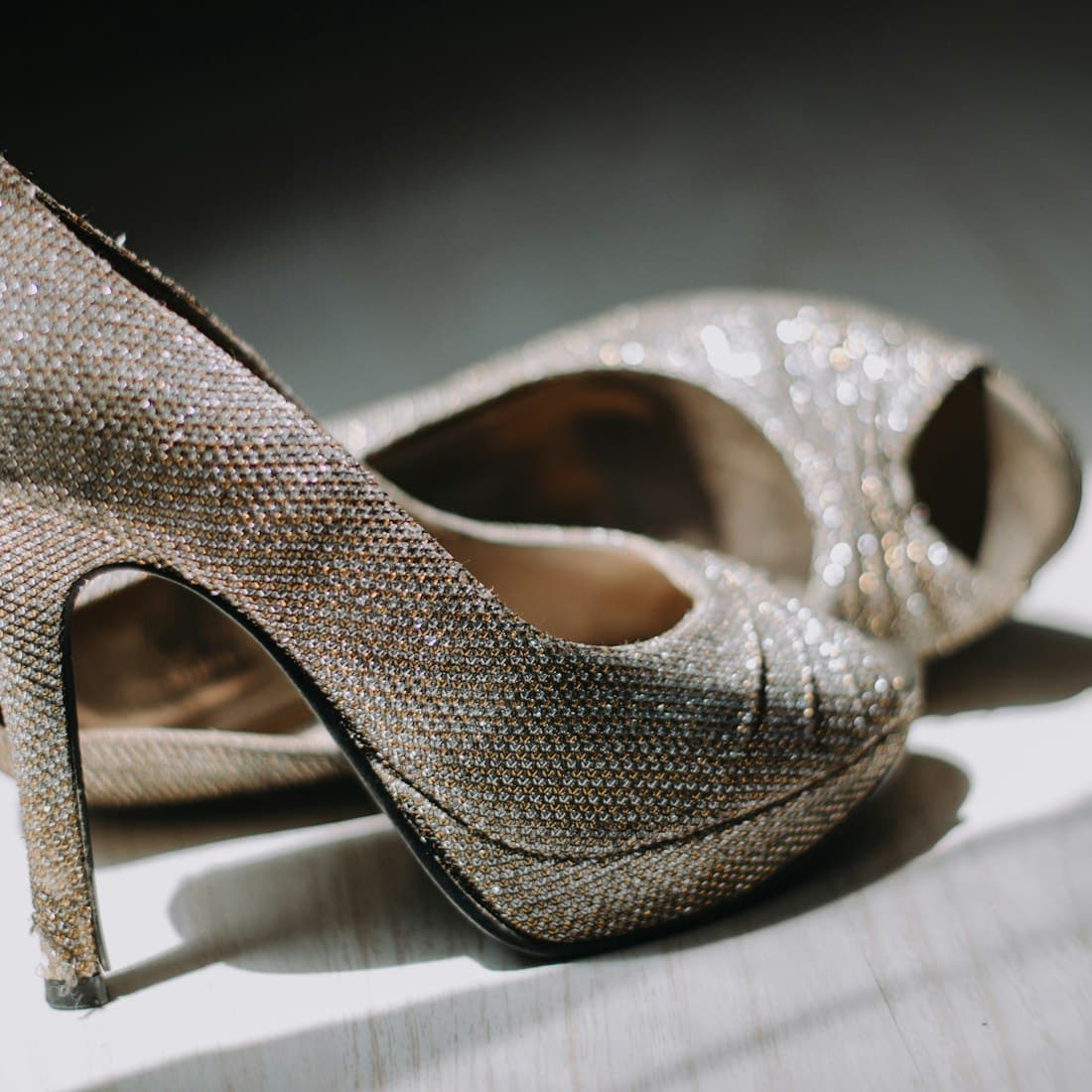 close up photography of pair of silver leather platform stilettos