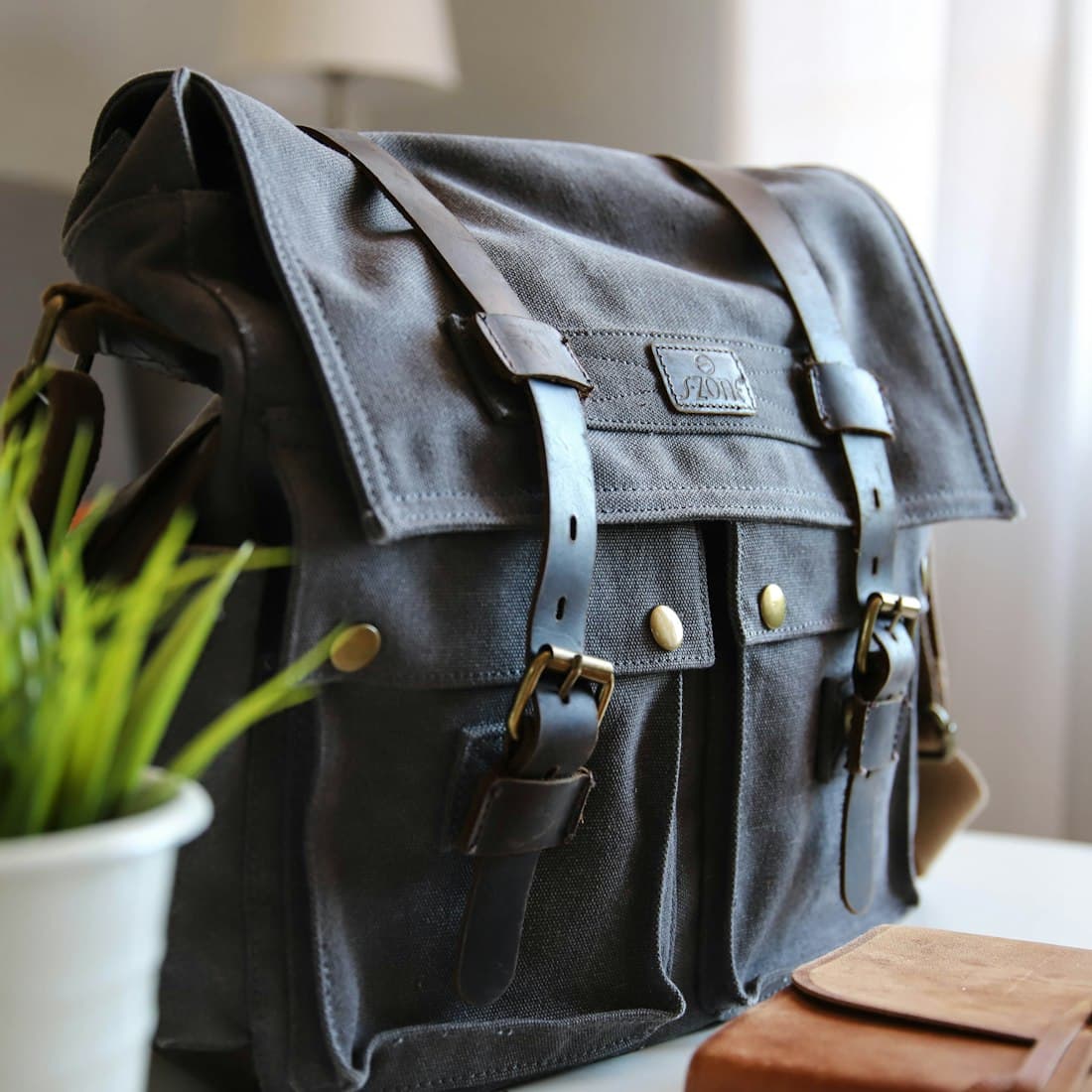 black leather satchel bag on white top