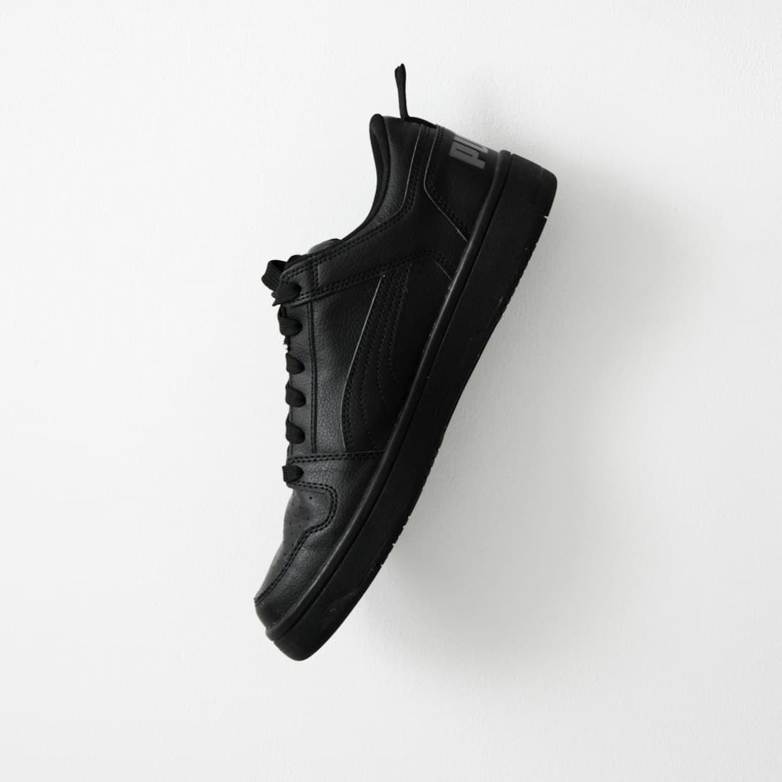 a pair of black shoes hanging on a wall