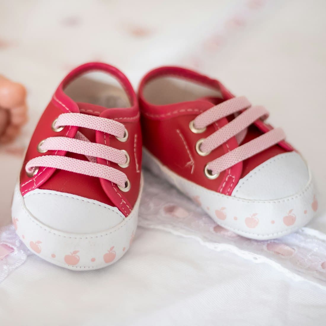 a close up of a baby's shoes on a bed