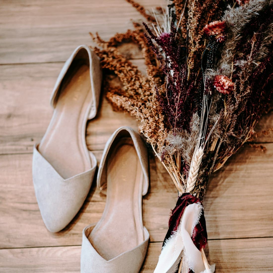 pair of shoes beside flowers