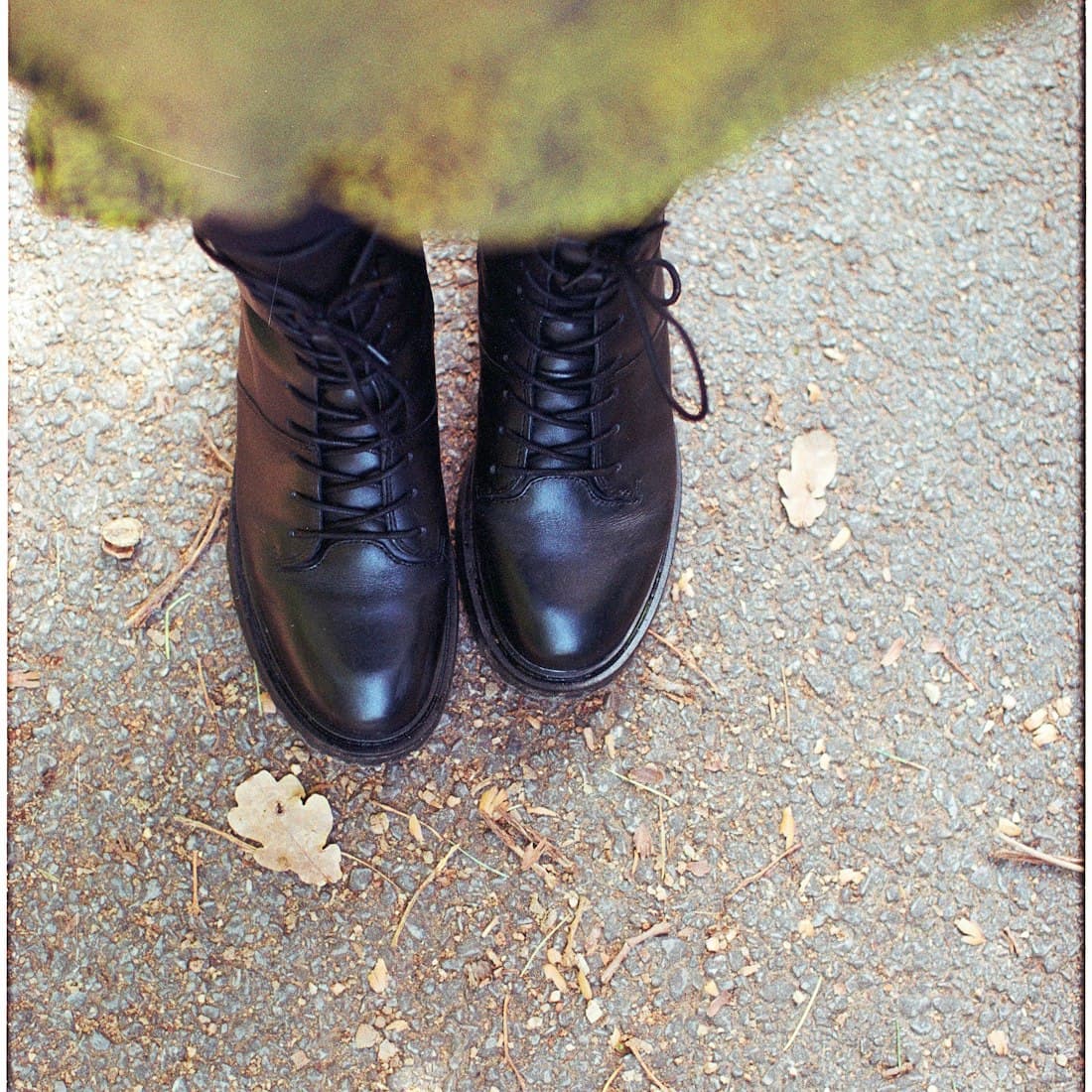 Black lace-up boots on a gravel path