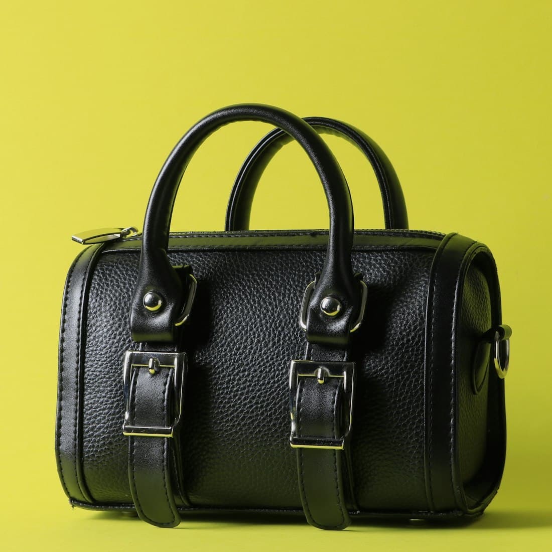a black leather bag on a yellow background