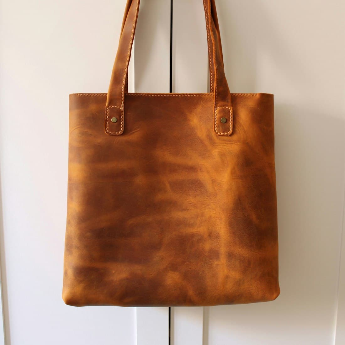 brown leather handbag on white table