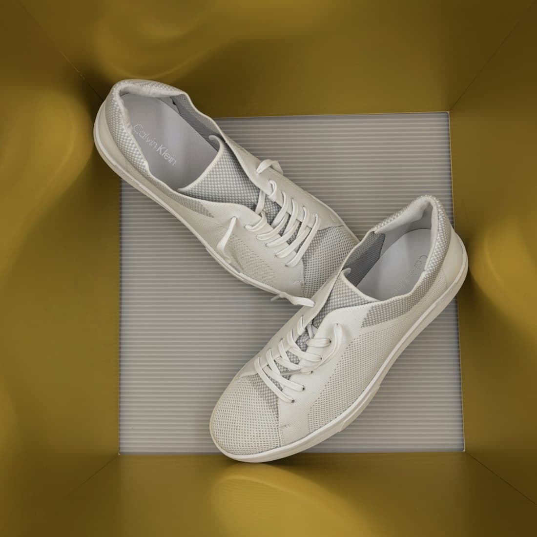 a pair of white tennis shoes sitting on top of a mat