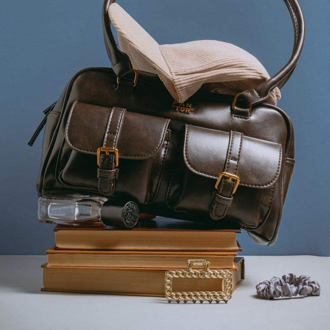 A brown bag sitting on top of a pile of books