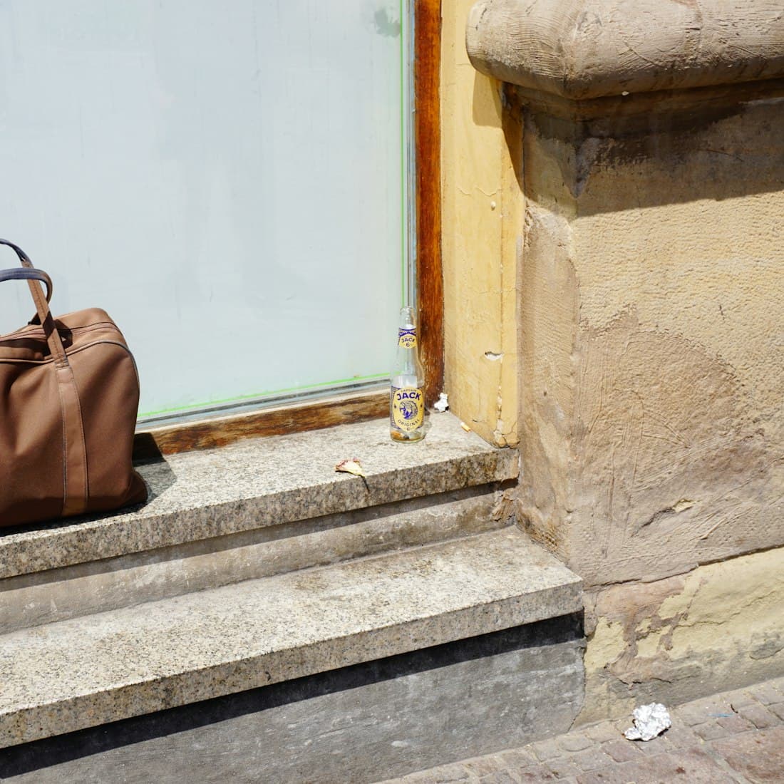 A brown bag sits on stone steps outside a building