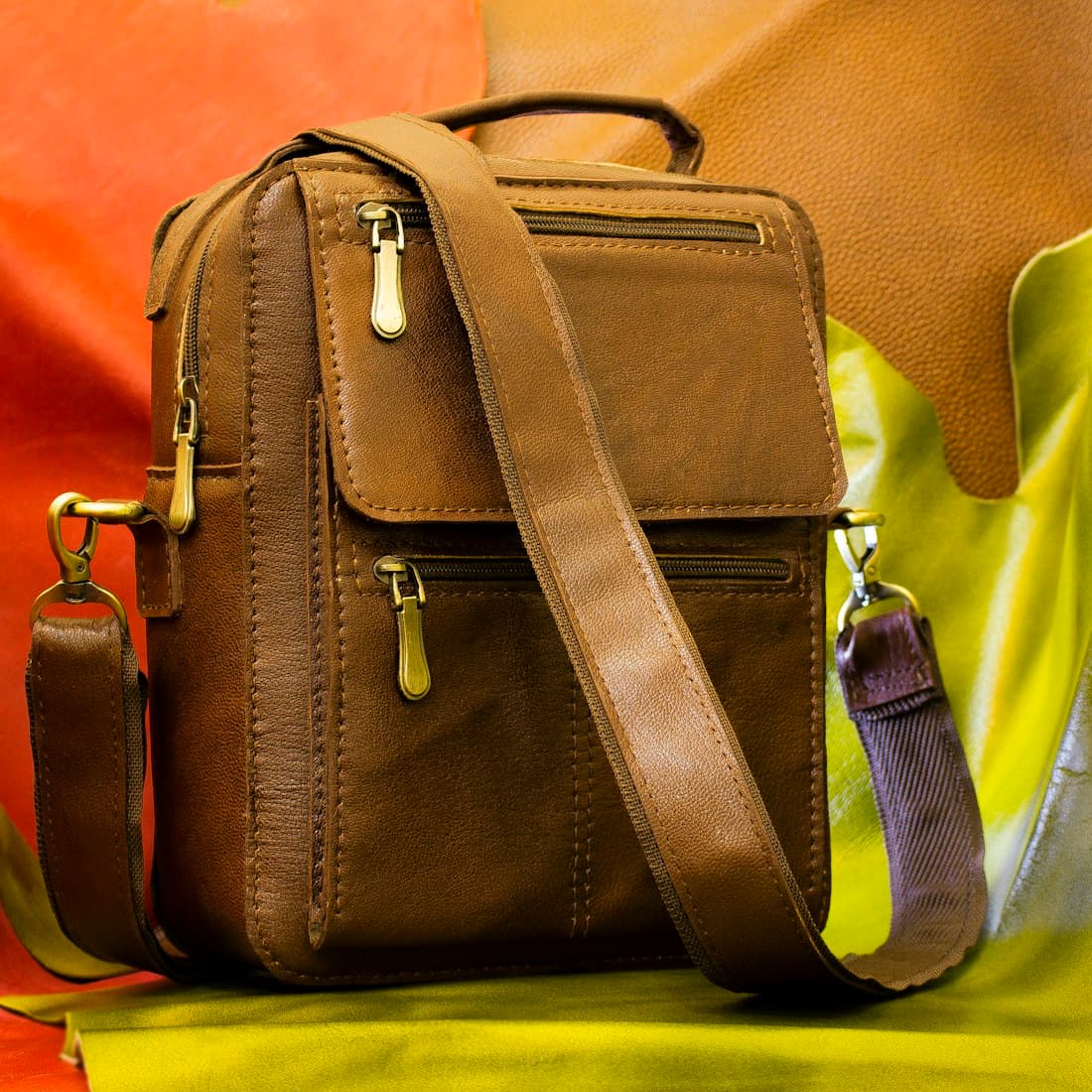 black leather sling bag on yellow leather chair